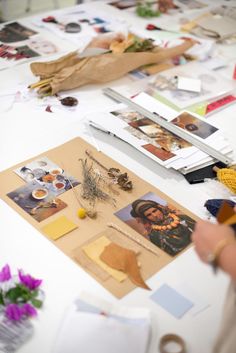 the table is covered with pictures and papers