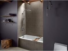 a bathroom with a toilet and a bathtub next to a wall mounted shower head