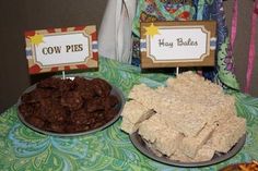 a table topped with two plates filled with food next to a sign that says cow pies