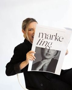 a woman holding up a sign with the words marke lines on it and an image of a woman's face