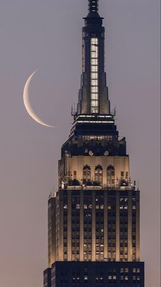 the moon is seen over the top of a building