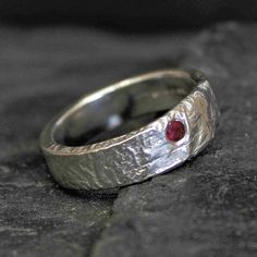 "Chunky Organic Ruby & Silver Ring | Red Ruby Molten Sterling Silver Ring | Unusual Shape Chunky Band | Naturally Formed .925 Ring The Ruby Frost Ring is a very classic organic sterling silver band. The faceted Ruby has been slightly off set in the ring and simply beautiful in this organic ring.  The Frost ring is a great and comfortable ring which measures approximately 6mm wide and roughly 2mm thick. It's got a lovely weight to it and it's a great all rounder. We have had a lot of couples over the years choose this band.  The organic textures are created applying heat several times to a piece of silver sheet. Each ring is individually hand crafted and each ring has it's own character.  DIMENSIONS Solid and weighing approximately 7-9 grams  Width: 6 mm Thickness:  2 mm This is a MADE TO O Ruby Birthstone Ring With Polished Finish For Wedding, Sterling Silver Ruby Ring With Diamond Cut For Anniversary, Wedding Ruby Ring With Diamond Cut In Sterling Silver, Red Jewelry With Tension Setting For Anniversary, Organic Wedding Band, Ruby Silver Ring, How To Wear Rings, Rustic Rings, Organic Wedding