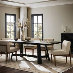 a dining room table with chairs and a potted plant in the center on a rug