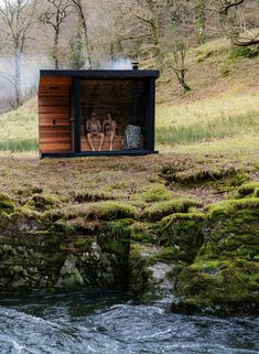 two people are sitting in the back of a small cabin on top of a cliff