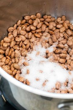 a large metal bowl filled with lots of white stuff next to a stove top oven