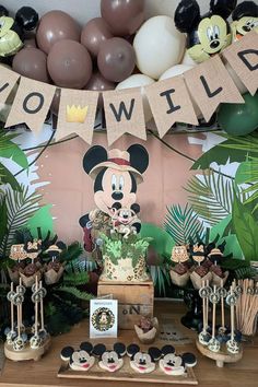 a mickey mouse themed birthday party with balloons and decorations