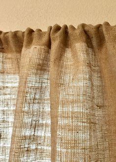 a close up view of a curtain with the curtains pulled back to reveal burlap