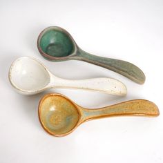 three ceramic spoons sitting next to each other