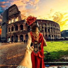 a man and woman are holding hands in front of the colossion at sunset