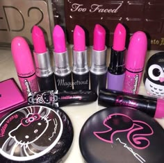 pink and black makeup is displayed on a counter top next to other beauty products, including lipstick