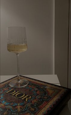 a glass of wine sitting on top of a table next to a book with the word 2010 written on it