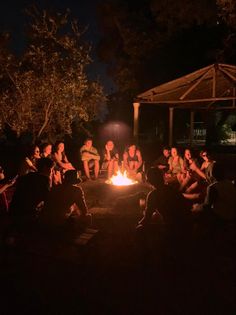 a group of people sitting around a fire pit