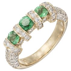 Emerald pave diamond wedding band ring. 3 round cut bright emeralds with 86 round accent diamonds in 18k yellow gold. 1 round bright green Emerald, approx. total weight .32cts, MI 2 round bright green Emeralds, approx. total weight .46cts, MI 86 round diamonds, approx. total weight .86cts, H, VS – SI Size 7 and sizable 18k yellow gold 8.3 grams Tested: 18k Stamped: 750 Width at top: 5.64mm Height at top: 5.37mm Width at Bottom: 3.48mm Pave Diamond Wedding Bands, Pave Wedding Bands, Emerald Gemstone, Three Stone Rings, Gold Wedding Band, Three Stone, Gold Wedding, Diamond Wedding, Diamond Wedding Bands