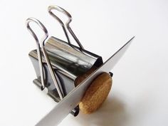 a pair of scissor holders with corks in them on a white surface