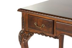 a wooden table with two drawers on one side and an ornate drawer on the other