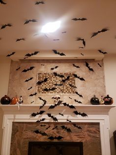 bats are flying in the air above a fireplace