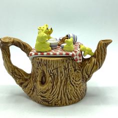 a ceramic teapot with winnie the pooh figurines on it