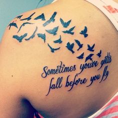 the back of a woman's shoulder with birds flying around it and some words written on