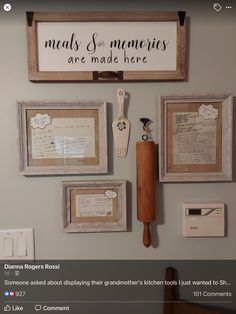 a wall with pictures and framed papers on it, including an old spatula in the middle