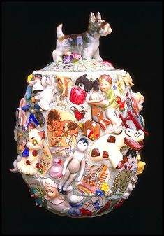 a glass vase with dogs on it and many other things in the bottom half of it