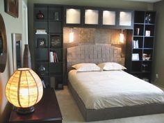 a bedroom with a bed, bookcases and lamps