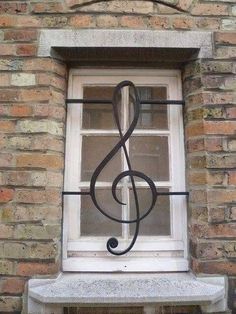 a treble on the window sill of a brick building with a glass pane