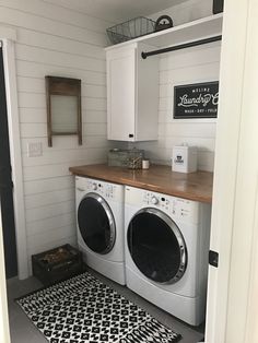 a washer and dryer in a laundry room with black and white rugs