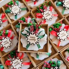 many small boxes filled with different types of christmas decorations and ribbons on top of each other