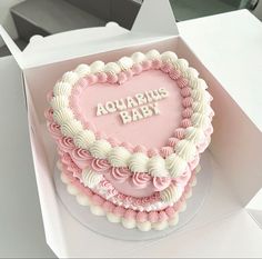 a pink and white heart shaped cake in a box