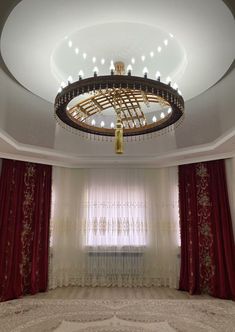 a large room with curtains, chandelier and drapes on the windowsill