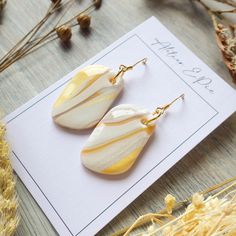 ⚪ DESCRIPTION: Pair of white and golden-yellow earrings reminiscent of calissons. In polymer clay, varnished with epoxy resin and golden stainless steel for the fasteners. Each pair being handmade, the patterns may vary slightly for each earring. These earrings are designed and made by me in France in polymer clay, a very light material, which makes them particularly comfortable to wear all day long. To complete an everyday outfit, or for an occasion, it's the little detail that makes the differ Modern White Resin Earrings, Hand Painted Gold Polymer Clay Earrings, Minimalist Yellow Earrings For Gift, Modern White Rectangular Earrings, Hand Painted White Earrings As A Gift, Yellow Rectangular Earrings Gift, Hand Painted White Earrings For Gift, Yellow Rectangular Earrings As A Gift, White Hand Painted Earrings For Gift