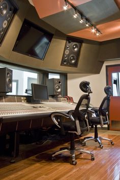 an empty recording studio with many monitors and keyboards