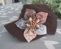 ALL ORDERS TOTALING OVER $35 SHIP FREE I designed this brown cadet military hat making a darling petal flower with contrasting fabrics. I added a beaded brooch center to the middle of the flower. If you do not like the center I have others just let me know.  Adjustable velcro back. See more of my cadet and baseball trucker hats here: https://www.etsy.com/shop/theraggedyrose?ref=seller-platform-mcnav&section_id=10557807 Thanks for visiting my shop. Michele Brown Military Brimmed Hat, Brown Military Hat, One Size Fits Most, Brown Military Flat Cap, Military Style Brown Flat Cap, Brown Military Style Flat Cap, Military Style Brown Baseball Cap, Brown Bucket Hat One Size Fits Most, Military Style Brown Cap, Brown Military Style Cap