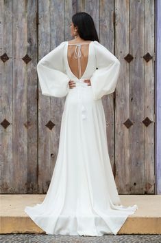 the back of a woman's wedding dress, with her hands on her hips