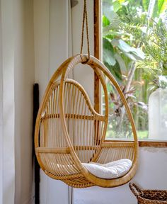 a hanging chair in front of a window