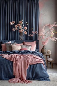 a bed with blue sheets and pink pillows in front of a curtained window filled with flowers