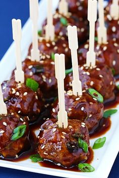 meatballs with sauce and toothpicks on a white plate