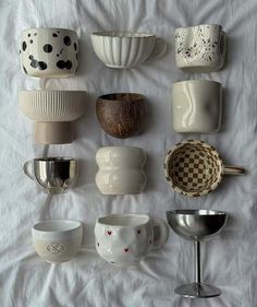 there are many different bowls and cups on the table together, all in various shapes and sizes