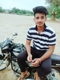 a man sitting on top of a motorcycle in the dirt next to a parked motorbike