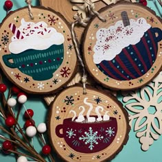 three wooden ornaments with designs on them and snowflakes hanging from the tree branch