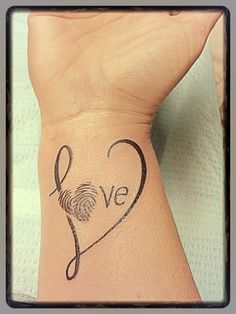 a woman's wrist tattoo with the word love written on it