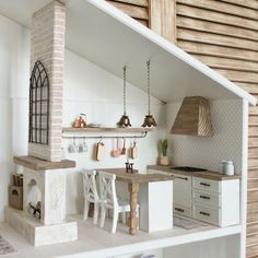 a doll house kitchen with all white furniture and accessories