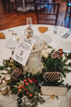 a white table topped with pine cones and candles