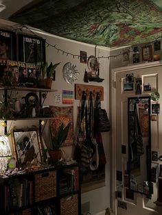 a room filled with lots of clutter and pictures hanging on the wall next to a door