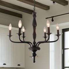 a chandelier hanging from the ceiling in a kitchen