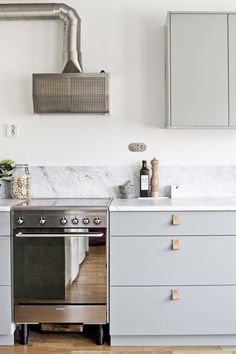 a kitchen with an oven, counter tops and cabinets in grey tones is pictured here