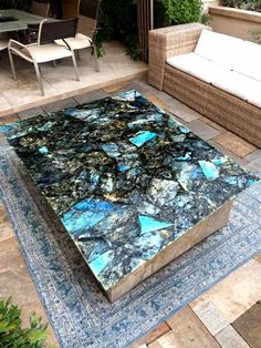 an outdoor table with blue and green marble on it in the middle of a patio