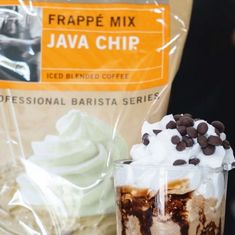 there is a drink with whipped cream and chocolate chips in it next to a bag of coffee beans