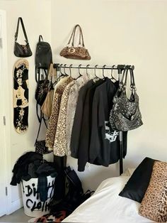 there are many purses and handbags hanging on the rack in this room,