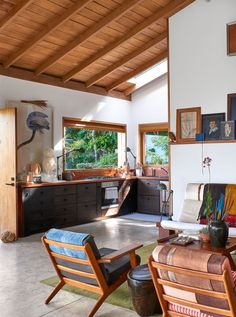 a living room filled with furniture and lots of windows next to a wall covered in pictures